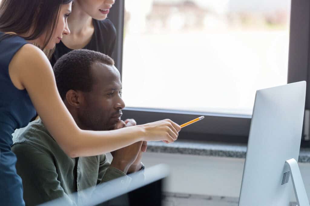 Three university administrators work together on managing student systems.