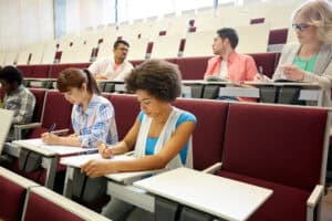 Students sit and take notes in a lecture hall.