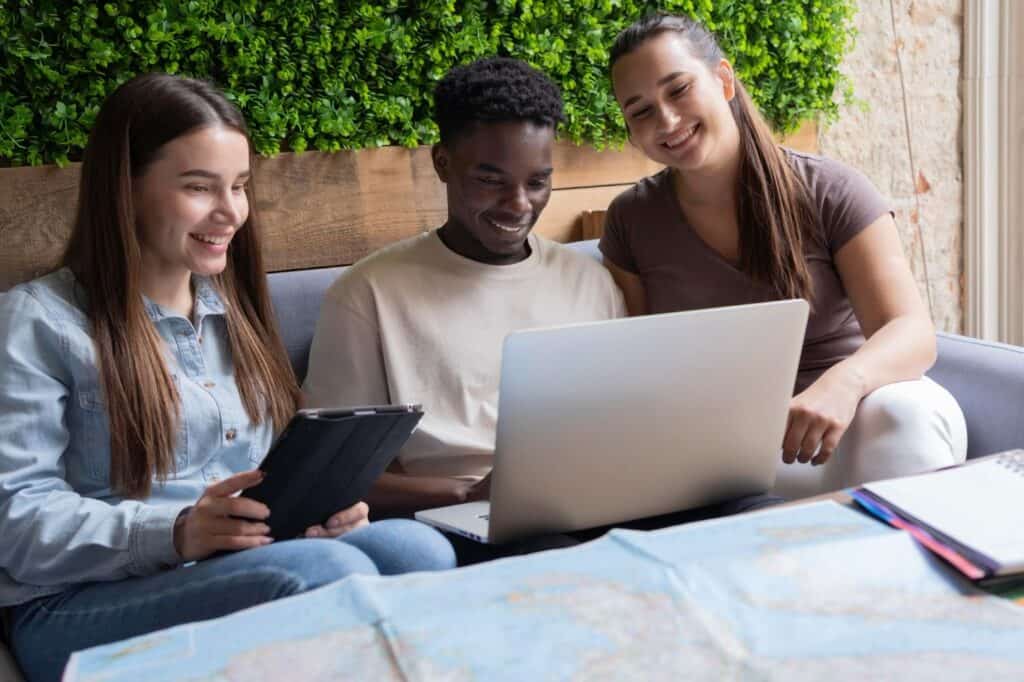 Three friends studying inclusion in higher education on a laptop together.